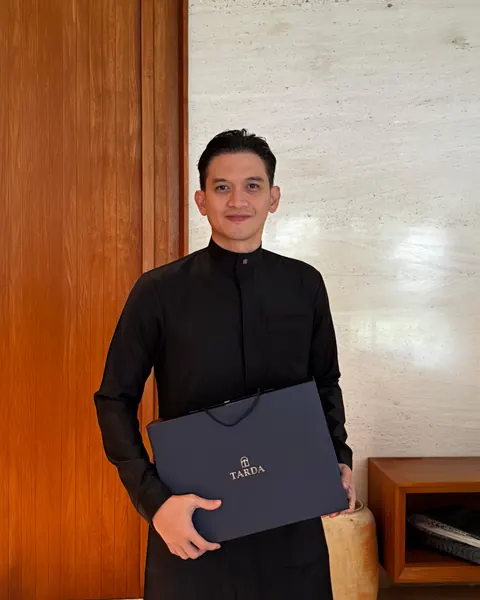 Rezky Aditya mengenakan thobe Tarda, memegang kotak Tarda